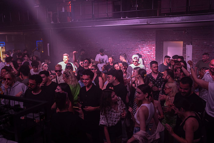 A packed dance floor under purple lights