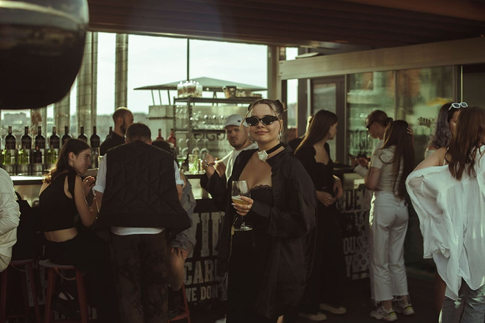 A guest dancing at a rooftop party at dusk